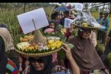 Warga mengarak makanan beubeutian atau makanan tradisional pada Festival Kolecer dan Beubeutian di Kampung Cisayong, Kabupaten Tasikmalaya, Jawa Barat, Minggu (31/7/2022). Acara tersebut merupakan tradisi budaya lokal hajat lembur sebagai rasa syukur warga atas melimpahnya hasil bumi. ANTARA FOTO/Adeng Bustomi/nym.