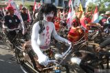 Peserta berkostum unik mengikuti kegiatan Parade Sepeda Tua Nusantara di Gor Jayabaya, Kota Kediri, Jawa Timur, Minggu (31/7/2022). Kegiatan bersepeda sejauh 17 kilometer menggunakan sepeda tua dan berkostum unik tersebut diikuti oleh sedikitnya 5 ribu peserta dari penjuru nusantara. Antara Jatim/Prasetia Fauzani/zk.