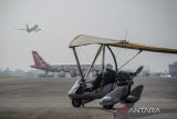 Pilot mengendarai pesawat jenis microlight di Lanud Husein Sastranegara, Bandung, Jawa Barat, Minggu (31/7/2022). Dalam rangka Peringatan Hari Bakti ke-75 TNI AU, Pangkalan TNI AU Husein Sastranegara menggelar aksi demo udara pesawat microlight dan kedirgantaraan lainnya, serta pameran pesawat Hercules yang terbuka bagi umum. ANTARA FOTO/Raisan Al Farisi/agr