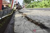  Warga menunjukan jalan yang retak akibat pergerakan tanah di Desa Nasol, Kabupaten Ciamis, Jawa Barat, Selasa (2/8/2022). Sebanyak 25 rumah warga retak akibat pergerakan tanah dan warga masih bertahan dirumahnya sambil meningkatkan kewaspadaan. ANTARA FOTO/Adeng Bustomi/agr
