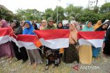 Warga memperlihatkan bendera merah putih yang diserahkan Pj Wali Kota Banda Aceh Bakri Siddiq di Kecamatan Meuraxa, Banda Aceh, Jumat (5/8/2022). Penyerahan bendera merah putih untuk dikibarkan di pekarangan rumah pada tanggal 1 hingga 31 Agustus 2022 sebagai bentuk dukungan Pemerintah Kota Banda Aceh terhadap program gerakan nasional 10 juta bendera merah putih dari Sabang hingga Merauke yang digagas Kementerian Dalam Negeri dalam rangka menyambut dan menyemarakkan peringatan HUT ke-77 Kemerdekaan RI. ANTARA/Irwansyah Putra