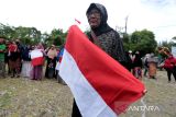 Warga memperlihatkan bendera merah putih yang diserahkan Pj Wali Kota Banda Aceh Bakri Siddiq di Kecamatan Meuraxa, Banda Aceh, Jumat (5/8/2022). Penyerahan bendera merah putih untuk dikibarkan di pekarangan rumah pada tanggal 1 hingga 31 Agustus 2022 sebagai bentuk dukungan Pemerintah Kota Banda Aceh terhadap program gerakan nasional 10 juta bendera merah putih dari Sabang hingga Merauke yang digagas Kementerian Dalam Negeri dalam rangka menyambut dan menyemarakkan peringatan HUT ke-77 Kemerdekaan RI. ANTARA/Irwansyah Putra