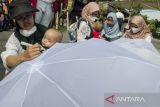 Peserta dari Asosiasi Ibu Menyusui Indonesia (AIMI) Jabar menulis aspirasi pada payung putih saat Aksi Payung AspirASI di Bandung, Jawa Barat, Minggu (7/8/2022). Aksi memperingati pekan menyusui Internasional 2022 tersebut untuk menyampaikan edukasi, peran dan dukungan seluruh masyarakat dalam menyukseskan program pemberian ASI eksklusif sesuai aturan UU No.36 Tahun 2009 tentang kesehatan. ANTARA FOTO/Novrian Arbi/agr