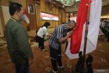 Salah satu mantan anggota Jamaah Islamiyah (JI) mencium bendera Merah Putih saat melakukan ikrar setia kepada NKRI dan Pancasila serta melepas baiat (janji taat) kepada JI di Kantor Gubernur Jawa Timur di Surabaya, Jawa Timur, Senin (8/8/2022). Kegiatan tersebut diikuti 15 mantan anggota dan simpatisan Jamaah Islamiyah (JI) dari berbagai daerah di Jawa Timur. Antara Jatim/Moch Asim/zk.