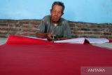 Alfan Efendi (74) menyelesaikan pembuatan bendera di Kelurahan Kaliwungu, Kabupaten Jombang, Jawa Timur, Jumat (5/8/2022). Memasuki awal Agustus, perajin mulai kebanjiran order pemesanan bendera merah putih serta umbul-umbul yang dijual mulai Rp25 ribu-Rp100 ribu. Antara Jatim/Syaiful Arif/zk.