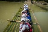 Siswa Menyeberangi Sungai Dengan Rakit Bambu