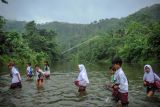 Sejumlah siswa menyeberangi Sungai Ciujung untuk sekolah di Desa Sukaluyu, Cikadu, Cianjur Selatan, Kabupaten Cianjur, Jawa Barat, Rabu (10/8/2022). Sejak tahun 2018, ratusan siswa dari Desa Karyabakti terpaksa harus menerjang Sungai Ciujung untuk sekolah di SDN Padawaras Desa Sukaluyu karena tidak ada akses jalan lain untuk menuju sekolah mereka. ANTARA FOTO/Raisan Al Farisi/YU
