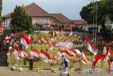 Pelajar melintasi halaman Gedung Perundingan Linggarjati yang berhias 10.001 Bendera Merah Putih di Kuningan, Jawa Barat, Kamis (11/8/2022). Pemasangan 10.001 Bendera Merah Putih tersebut dalam rangka menyambut perayaan HUT ke-77 Kemerdekaan RI. ANTARA FOTO/Dedhez Anggara/agr