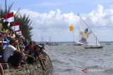 Warga menyaksikan sejumlah perahu layar saling beradu kecepatan di Pantai Kenjeran Surabaya, Jawa Timur, Sabtu (13/8/2022). Sedikitnya 40 perahu layar beradu dalam perlombaan yang digelar  untuk menyemarakan hari kemerdekaan Republik Indonesia ke-77. ANTARA Jatim/Hildaniar Novitasari/ZK