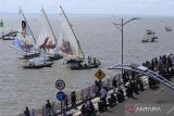 Warga menyaksikan sejumlah perahu layar saling beradu kecepatan di Pantai Kenjeran Surabaya, Jawa Timur, Sabtu (13/8/2022). Sedikitnya 40 perahu layar beradu dalam perlombaan yang digelar  untuk menyemarakan hari kemerdekaan Republik Indonesia ke-77. ANTARA Jatim/Hildaniar Novitasari/ZK