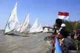 Warga menyaksikan sejumlah perahu layar saling beradu kecepatan di Pantai Kenjeran Surabaya, Jawa Timur, Sabtu (13/8/2022). Sedikitnya 40 perahu layar beradu dalam perlombaan yang digelar  untuk menyemarakan hari kemerdekaan Republik Indonesia ke-77. ANTARA Jatim/Hildaniar Novitasari/ZK