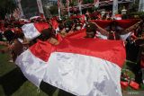 Sejumlah anggota Pramuka membentangkan Bendera Merah Putih di sela-sela acara Gerakan Nasonal Pembagian 10 Juta Bendera Merah Putih di Gedung Negara Grahadi, Surabaya, Jawa Timur, Minggu (14/8/2022). Kegiatan tersebut merupakan salah satu upaya dalam meningkatkan patriotisme dan nasionalisme masyarakat di seluruh Indonesia. Antara Jatim/Moch Asim/zk.