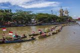 Sejumlah pedagang pasar terapung melakukan atraksi berbaris meggunakan perahu (jukung) saat Festival Budaya Pasar Terapung di Sungai Martapura, Banjarmasin, Kalimantan Selatan, Senin (15/8/2022). Atraksi yang dilakukan puluhan pedagang pasar terapung itu digelar unutk memeriahkan HUT ke-77 RI dan puncak HUT Provinsi Kalimantan Selatan ke-72. ANTARA FOTO/Bayu Pratama S/nym.