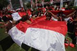 Sejumlah anggota Pramuka membentangkan Bendera Merah Putih pada acara Gerakan Nasonal Pembagian 10 Juta Bendera Merah Putih di Gedung Negara Grahadi, Surabaya, Jawa Timur, Minggu (14/8/2022). Kegiatan tersebut sebagai salah satu upaya dalam meningkatkan patriotisme dan nasionalisme masyarakat di seluruh Indonesia. ANTARA FOTO/Moch Asim/tom.
