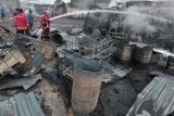 Petugas Dinas Pemadam Kebakaran Kota Jambi melakukan pendinginan saat terjadi kebakaran di salah satu gudang minyak di Jambi, Senin (15/8/2022). Tidak ada korban jiwa dalam kejadian itu namun kerugian ditaksir mencapai ratusan juta rupiah. ANTARA FOTO/Wahdi Septiawan/foc.