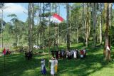 Warga dan mahasiswa mengenakan busana adat Bali saat mengikuti pengibaran bendera merah putih di kawasan Hutan Desa Manistutu, Jembrana, Bali, Selasa (16/8/2022). Kegiatan yang digelar oleh mahasiswa Universitas Hindu Negeri I Gusti Bagus Sugriwa yang melaksanakan kuliah kerja nyata (KKN) di desa tersebut untuk memeriahkan HUT ke-77 Kemerdekaan Republik Indonesia serta mengajak masyarakat untuk menjaga dan melestarikan hutan. ANTARA FOTO/Nyoman Hendra Wibowo/nym.
