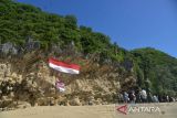 Mahasiswa Pecinta Alam (Mapala) bersama TNI dan masyarakat mengibarkan bendera raksasa di kawasan wisata Pantai Tebing, Desa Meunasah Balee, Kabupaten Aceh Besar, Aceh, Rabu 17/8/2022). Pengibaran bendera berukuran 16 meter  x  4 meter di kawasan wisata  itu dalam rangka memeriahkan HUT ke-77 Kemerdekaan RI. ANTARA FOTO/Ampelsa.