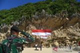 Mahasiswa Pecinta Alam (Mapala) bersama TNI dan masyarakat mengibarkan bendera raksasa di kawasan wisata Pantai Tebing, Desa Meunasah Balee, Kabupaten Aceh Besar, Aceh, Rabu 17/8/2022). Pengibaran bendera berukuran 16 meter  x  4 meter di kawasan wisata  itu dalam rangka memeriahkan HUT ke-77 Kemerdekaan RI. ANTARA FOTO/Ampelsa.