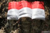 Sejumlah pemanjat tebing membentangkan bendera merah putih raksasa dalam upacara bendera memperingati  HUT Kemerdekaan RI Ke-77 di tebing Lembah Kera, Malang, Jawa Timur, Rabu (17/8/2022). Upacara bendera tersebut diadakan untuk memupuk rasa nasionalisme sekaligus menanamkan kepedulian terhadap alam. ANTARA Jatim/Ari Bowo Sucipto/zk