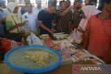 Menteri Perdagangan Zulkifli Hasan (ketiga kiri) membeli tempe untuk dibagikan kepada pengunjung saat meninjau ketersediaan bahan pangan, daging ayam potong di Pasar Al Mahirah, Banda Aceh, Aceh, Jumat (19/8/2022). Kunjungan kerja tersebut  untuk melihat dan memantau langsung harga dan ketersediaan berbagai jenis bahan pangan dalam pemenuhan kebutuhan masyarakat. ANTARA FOTO/Ampelsa.