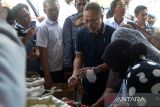 Menteri Perdagangan Zulkifli Hasan (kedua kanan) berbelanja bawang merah untuk dibagikan kepada pengunjung  di Pasar Al Mahirah, Banda Aceh, Aceh, Jumat (19/8/2022). Kunjungan kerja tersebut  untuk melihat dan memantau langsung harga dan ketersediaan berbagai jenis bahan pangan dalam pemenuhan kebutuhan masyarakat. ANTARA FOTO/Ampelsa.