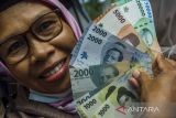Warga menunjukkan pecahan uang rupiah kertas terbaru saat penukaran di Gedung Sate, Bandung, Jawa Barat, Jumat (19/8/2022). Warga antusias menukarkan uang rupiah kertas tahun emisi 2022 yang dikeluarkan Bank Indonesia (BI) yang terdiri atas pecahan Rp100.000, Rp50.000, Rp20.000, Rp10.000, Rp5.000, Rp2000, dan Rp1000. ANTARA FOTO/Novrian Arbi/agr