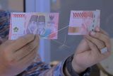 Kepala Bank Indonesia (BI) Perwakilan wilayah NTT I Nyoman Ariawan Atmaja menunjukkan uang kertas baru pecahan Rp100 ribu (kiri) dan pecahan Rp100 ribu lama saat peluncurannya di Kota Kupang, NTT, Kamis (18/8/2022). BI meluncurkan tujuh pecahan Uang Rupiah Kertas Tahun Emisi 2022, dengan nominal Uang TE 2022 pecahan Rp1.000, Rp2.000, Rp5.000, Rp10.000, Rp20.000, Rp50.000, dan Rp100.000. ANTARA FOTO/Kornelis Kaha/rwa.