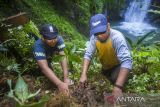 Pengelola wisata air terjun Haratai, Sukran (kanan), bersama mahasiswa Fakultas Pertanian Universitas Lambung Mangkurat menanam bibit kopi jenis Arabika di kawasan objek wisata tersebut di Kecamatan Loksado, Kabupaten Hulu Sungai Selatan, Kalimantan Selatan, Minggu (21/8/2022).  Serikat Petani Indonesia (SPI) Kalimantan Selatan bersama mahasiswa dan pihak pengelola wisata air terjun Haratai melakukan penanaman bibit kopi jenis Arabika, Liberika dan Robusta serta memberikan edukasi tentang tanaman kopi sebagai upaya meningkatkan ekonomi masyarakat setempat. Foto Antaranews Kalsel/Bayu Pratama S.