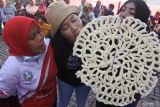 Sejumlah warga mengikuti lomba makan kerupuk jumbo di Kelurahan Ardirejo, Panji, Situbondo, Jawa Timur, Minggu (21/8/2022). Kegiatan tersebut dalam rangka memeriahkan HUT ke-77 RI. ANTARA Jatim/seno
