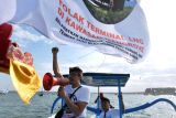 Pengunjukrasa berorasi saat mengikuti aksi pawai jukung untuk menolak Terminal Liquefied Natural Gas (LNG) di kawasan mangrove di Perairan Sanur, Denpasar, Bali, Minggu (21/8/2022). Mereka menolak rencana pembangunan Terminal LNG di kawasan mangrove yang dikhawatirkan dapat berdampak pada mata pencaharian nelayan setempat. ANTARA FOTO/Fikri Yusuf/YU