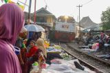 Kereta api melintas di pasar tradisional di pinggir rel, di Surabaya, Jawa Timur, Selasa (23/8/2022). Meskipun berbahaya, para pedagang tetap menjajakan dagangannya di sekitar rel tersebut setiap pagi karena alasan dekat dengan pemukiman warga. ANTARA Jatim/Hildaniar Novitasari/zk