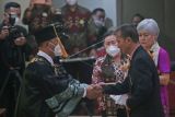 Ayah dari almarhum Brigadir Nopriyansyah Yosua Hutabarat atau Brigadir J, Samuel Hutabarat (kanan) didampingi istri Rosti Simajuntak (ketiga kanan) menerima ucapan selamat atas kelulusan anaknya dari Rektor Universitas Terbuka Ojat Darojat (kiri) saat acara prosesi wisuda di Kampus Universita Terbuka Pondok Cabe, Tangerang Selatan, Banten, Selasa (23/8/2022). Almarhum Brigadir Yosua diwisuda bersama 2499 mahasiswa lainnya sebagai Sarjana Ilmu Hukum oleh Universitas Terbuka. ANTARA FOTO/Muhammad Iqbal/rwa.