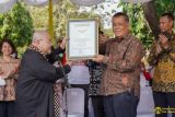 Rektor UI Prof. Ari Kuncoro ketika menerima penghargaan dari Pendiri MURI Prof. Dr. (HC). Jaya Suprana  untuk kategori “Mencanting Batik oleh Mahasiswa Baru Terbanyak” dan “Paduan Suara Mahasiswa Baru Terbanyak” yang dilakukan oleh 9.237 mahasiswa baru. (Foto:ANTARA/Humas UI)