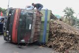 Seorang awak truk melihat kerusakan pada kendaraannya yang mengalami pecah ban dan terguling di bundaran Panglima Sudirman, Malang, Jawa Timur, Jumat (26/8/2022). Tidak ada korban jiwa dalam kejadian tersebut. ANTARA Jatim/Ari Bowo Sucipto/zk