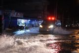 SINGKAWANG TERENDAM BANJIR AKIBAT HUJAN. Sebuah ambulans melintasi banjir di Jalan Alianyang, Kelurahan Pasiran, Kecamatan Singkawang Barat, Kota Singkawang, Kalimantan Barat, Sabtu (27/8/2022). Banjir menggenangi sejumlah ruas jalan, pemukiman penduduk dan fasilitas umum di Kota Singkawang akibat tingginya curah hujan sejak Sabtu (27/8/2022) siang hingga malam hari di wilayah setempat. ANTARA FOTO/Reza Novriandi/jhw