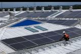 Pekerja memeriksa panel-panel surya dari Pembangkit Listrik Tenaga Surya (PLTS) di atap pabrik Danone-AQUA Mambal di Badung, Bali, Rabu (31/8/2022). PLTS di atap pabrik tersebut merupakan PLTS atap terbesar yang diinisiasi oleh kalangan industri di Bali dengan kapasitas sistem sebesar 704 KWP dapat menghasilkan listrik sebesar 1050 MWH per tahun dan dapat mengurangi sebesar 882 ton CO2 per tahun sekaligus mendukung pelaksanaan Presidensi G20 dalam transisi energi berkelanjutan. ANTARA FOTO/Nyoman Hendra Wibowo/nym.