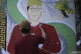 Seorang mahasiswa membuat mural di kampung pecinan Tambak Bayan, Surabaya, Jawa Timur, Jumat (2/9/2022). Kegiatan 