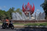 Wisatawan yang mengendarai sepeda motor melintas di dekat monumen G20 yang baru dibangun di Denpasar, Bali, Jumat (2/9/2022). Pembangunan monumen tersebut untuk menyambut Presidensi G20 Indonesia 2022 di Bali yang mengusung tema 'Recover Together, Recover Stronger'. ANTARA FOTO/Nyoman Hendra Wibowo/nym.
