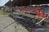 Pekerja membersihkan puing puing fasilitas tempat duduk yang dibakar penonton pascakerusuhan pertandingan sepakbola Persiraja Banda Aceh VS PSMS Medan di Stadion H Dimurthala Lampineung, Banda Aceh, Selasa (6/9/2022). Sejumlah fasilitas tempat duduk pesepakbola, panitia pertandingan, jaring gawang  dan fasilitas lainnya stadion rusak dibakar penonton yang kecewa akibat pertandingan Persiraja Banda Aceh VS PSMS Medan pada  kompentensi Liga II, Senin (5/9/2022) pukul 8.30 WIB tertunda akibat pemadaman listrik menjelang pertandingan dimulai. ANTARA FOTO/Ampelsa.