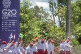 Sejumlah siswa SDN 45 Tanjungpandan mengibarkan bendera saat menyambut kedatangan perwakilan delegasi Development Working Group (DWG) G20 dari berbagai negara di Belitung, Kepulauan Bangka Belitung, Selasa (6/9/2022). Pertemuan tingkat menteri DWG G20 tersebut akan membahas soal pembangunan berkelanjutan berbasis masyarakat dan bernuasa maritim, yang akan dilaksanakan pada 7-9 September 2022. ANTARA FOTO/Muhammad Adimaja/rwa. 