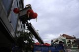 Pekerja memasang lampu lampion di Jalan Kembang Jepun, Surabaya, Jawa Timur, Kamis (8/9/2022). Pemerintah Kota Surabaya terus melakukan penataan fasilitas dan pemasangan pernak-pernik hingga pembuatan mural untuk membangkitkan kembali destinasi Wisata Pecinan Kya-Kya. Antara Jatim/Hildaniar Novitasari/mas.