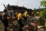 Sejumlah personel kepolisian, petugas Badan Penanggulangan Bencana Daerah (BPBD) bersama warga membersihkan reruntuhan rumah rusak dan warung roboh akibat angin kencang di Kabupaten Madiun, Jawa Timur, Jumat (9/9/2022). Hujan deras disertai angin kencang di dua desa di wilayah tersebut Kamis (8/9) mengakibatkan 53 rumah rusak, sebuah bangunan gudang dan dua warung roboh, sejumlah pohon tumbang serta dua orang warga mengalami luka. Antara Jatim/Siswowidodo/mas.