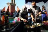 Kapolres Blitar AKBP Adhitya Panji Anom (Kanan) memasak nasi goreng di dapur umum saat Car Free Day dan Bakti Sosial (Baksos) menyambut HUT Polisi Lalulintas ke-67 di Alun-Alun Kanigoro, Blitar, Jawa Timur, Minggu (18/9/2022). Selain melaksanakan baksos berupa pemeriksaan kesehatan gratis, pembagian sembako, serta dapur umum, Satlantas Polres Blitar juga mennggelar edukasi berlalulintas yang baik melalui pembagian jaket dan helm kepada komunitas motor. Antara Jatim/Irfan Anshori/mas.