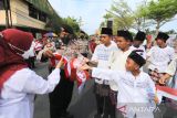 Polisi membagikan bendera Merah Putih kepada peserta saat mengikuti Kirab Kebangsaan di Indramayu, Jawa Barat, Rabu (21/9/2022). Kirab kebangsaan yang diikuti ratusan warga lintas agama, organisasi masyarakat, instansi pemerintah dan TNI-POLRI itu bertujuan untuk meningkatkan semangat persatuan dan kesatuan dalam kerangka NKRI. ANTARA FOTO/Dedhez Anggara/agr
