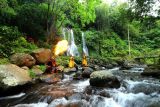 Seniman jaranan buto menyemburkan api dengan latar belakang air terjun Jagir di Banyuwangi, Jawa Timur, Kamis (22/09/2022). Sejumlah seniman tari bersama pengelola wisata mengkolaborasikan unsur seni daerah setempat sebagai pariwisata yang berbasis budaya (Cultural Tourism) untuk menambah daya tarik dan meningkatkan kunjungan wisata. ANTARA FOTO/Budi Candra Setya/wsj.