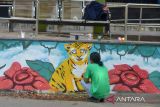 Peserta dari mahasiswa Institut Seni dan Budaya Indonesia (ISBI) Aceh menyelesaikan lukisan harimau  saat mengikuti lomba mural satwa dilindungi di Halte  Bis Trans Kutaraja, Banda Aceh, Aceh, Sabtu (24/9/2022). Lomba mural di  sejumlah Halte Bis Trans Kutaraja tersebut untuk  mengkampanyekan penyelematan satwa dilindungi dari ancaman kepunahan di provinsi Aceh.  ANTARA FOTO/Ampelsa.