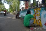 Peserta dari mahasiswa Institut Seni dan Budaya Indonesia (ISBI) Aceh menyelesaikan lukisan harimau  saat mengikuti lomba mural satwa dilindungi di Halte  Bis Trans Kutaraja, Banda Aceh, Aceh, Sabtu (24/9/2022). Lomba mural di  sejumlah Halte Bis Trans Kutaraja tersebut untuk  mengkampanyekan penyelematan satwa dilindungi dari ancaman kepunahan di provinsi Aceh.  ANTARA FOTO/Ampelsa.