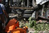 Petugas melihat kondisi korban terjepit truk tangki yang mengalami kecelakaan di simpang tiga Sukowidi,  Banyuwangi, Jawa Timur, Minggu (25/09/2022). Kecelakaan truk tangki pengangkut BBM berkapasitas 16 liter yang terguling menimpa sebuah warung itu mengakibatkan empat orang korban meninggal dunia. Antara Jatim/Budi Candra Setya/mas.