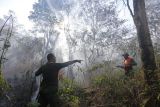 Petugas berusaha memadamkan kebakaran hutan dan lahan (karhutla) di Desa Cibuntu, Kecamatan Pesawahan, Kuningan, Jawa Barat, Senin (26/9/2022). Puluhan personel gabungan dari Balai Taman Nasional Gunung Ciremai (BTNGC), Masyarakat Peduli Api (MPA) dan personel TNI/Polri diterjunkan ke lokasi kebakaran untuk memadamkan api yang telah menghanguskan puluhan hektar kawasan hutan di lereng Gunung Ciremai. ANTARA FOTO/Dedhez Anggara/tom.