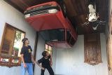 Rumah dan garasi mobil terbalik menjadi daya pikat pengunjung mendatangi kawasan wisata di Temajuk, Ahad (2/10) Kabupaten Sambas, Kalimantan Barat. Bangunan rumah dengan atap dibawah dan semua perabotan didalam juga terbalek mengundang penasaran pengunjung. Lokasi wisata Temajuk berbatasan langsung dengan Serawak, Malaysia. Foto Antara/Evy R. Syamsir.